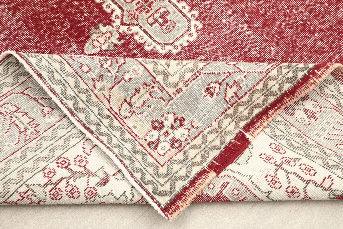 Folded corner of the rug, revealing the cotton foundation and the reverse side