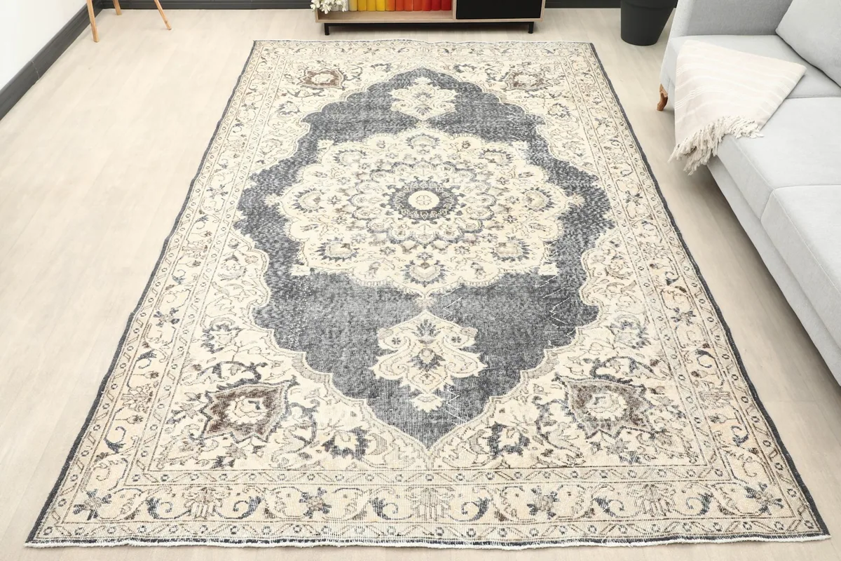 Vintage Anatolian rug with charcoal medallion in a room setting, overhead view