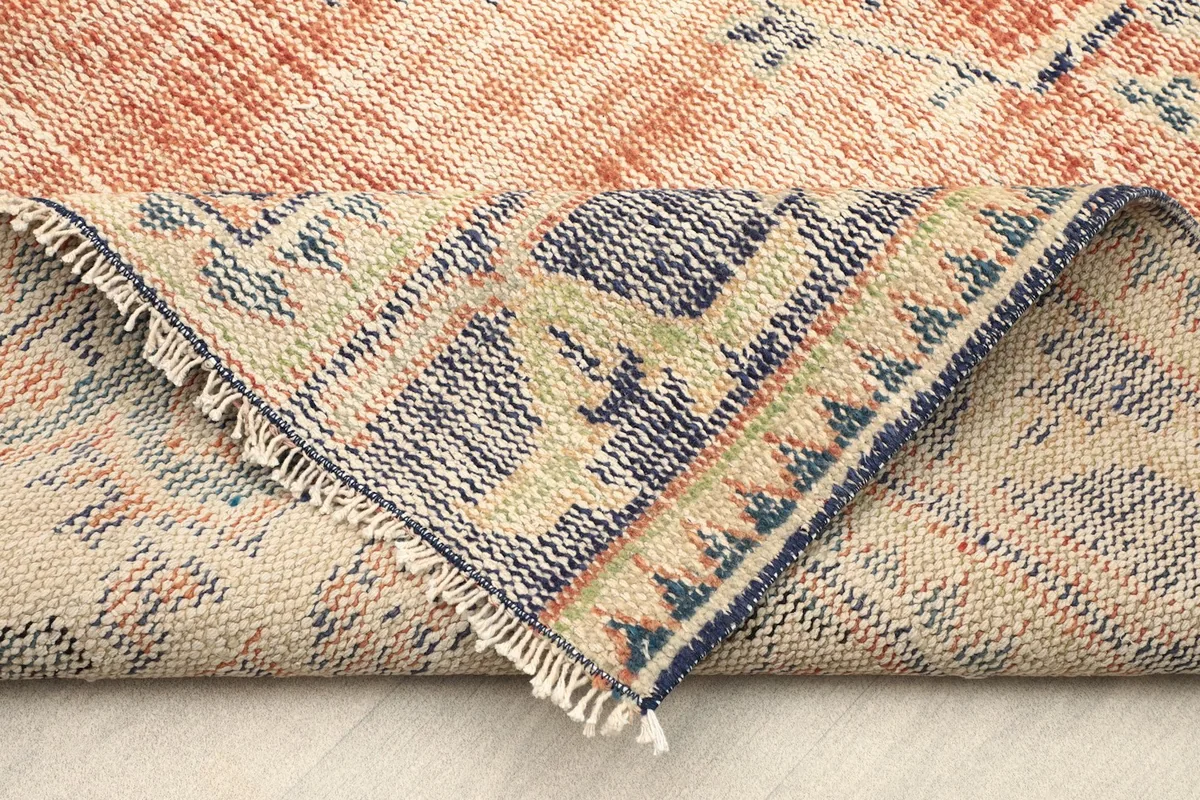 Folded corner of the rug revealing the hand-knotted cotton foundation and reverse side