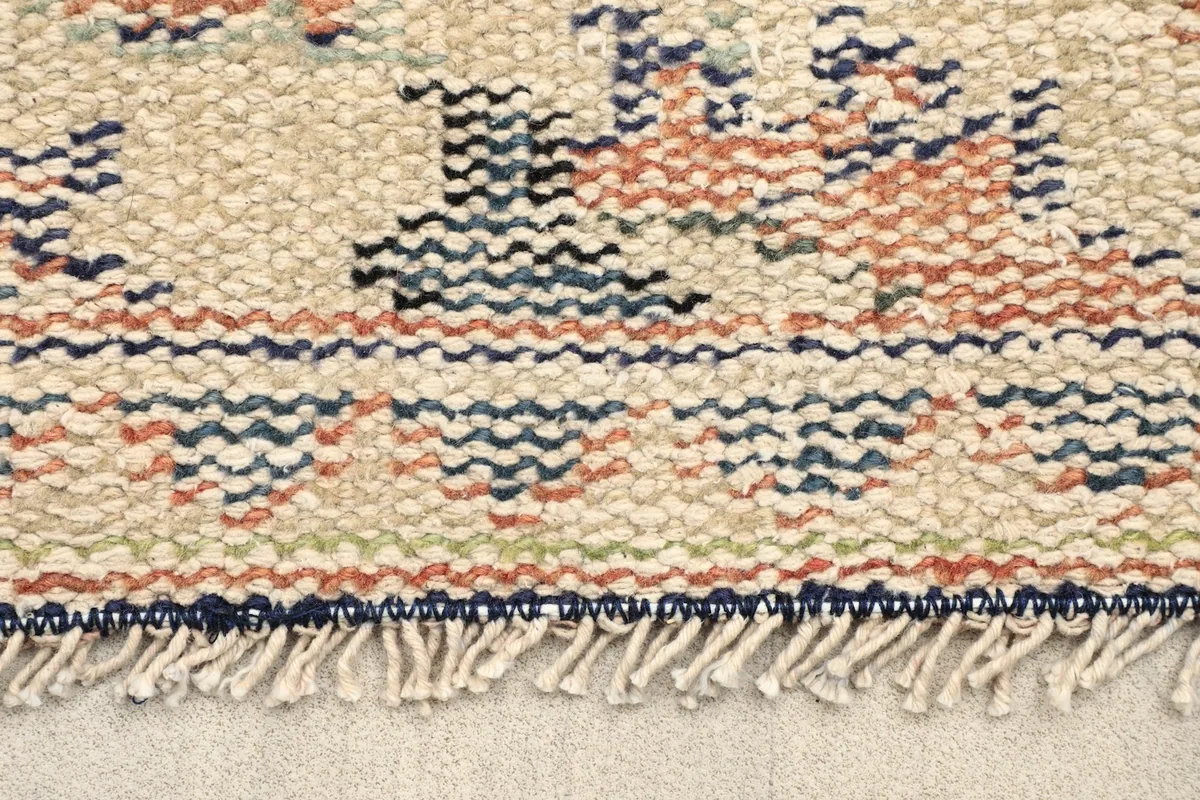 Close-up of the short, hand-knotted fringe and a corner of the rug