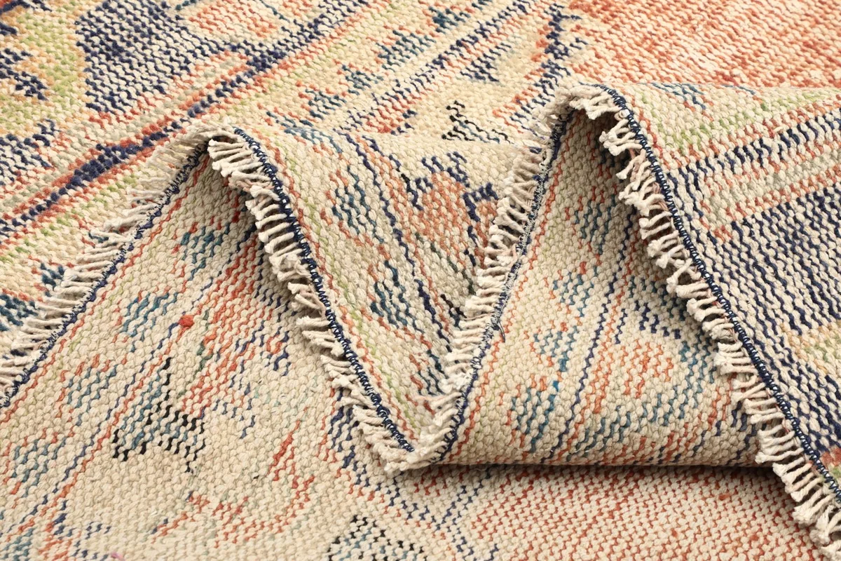 Zig-zag fold of the rug showcasing the flexible cotton foundation and weave