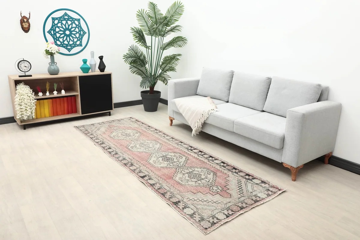 Full room view showing the rose geometric runner rug extending along a wall with a sofa