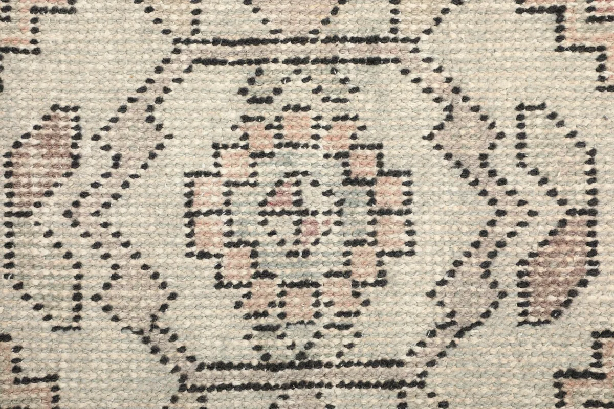Macro view of the low wool pile and hand-knotted texture of the rug