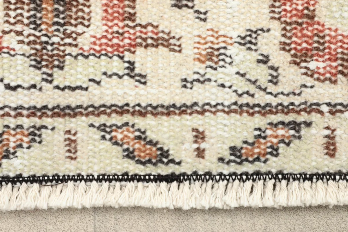Close-up detail of the fringe and border pattern of the vintage Anatolian rug.