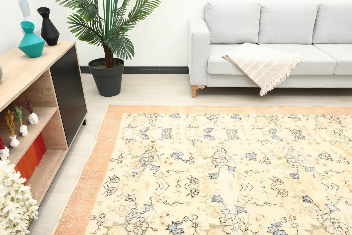 Room shot showing the rug's texture and colors in natural light next to a sofa