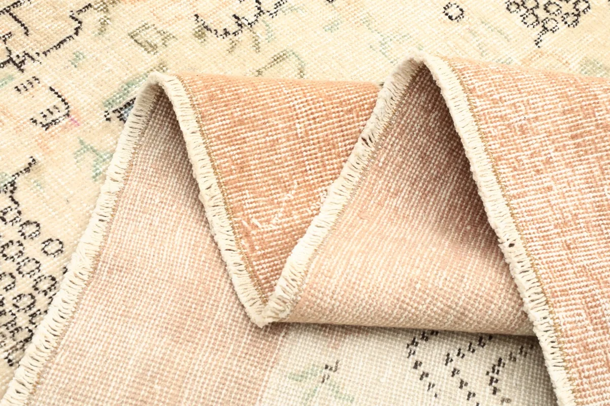 Side view of the rug's low pile and hand-knotted construction along a fold