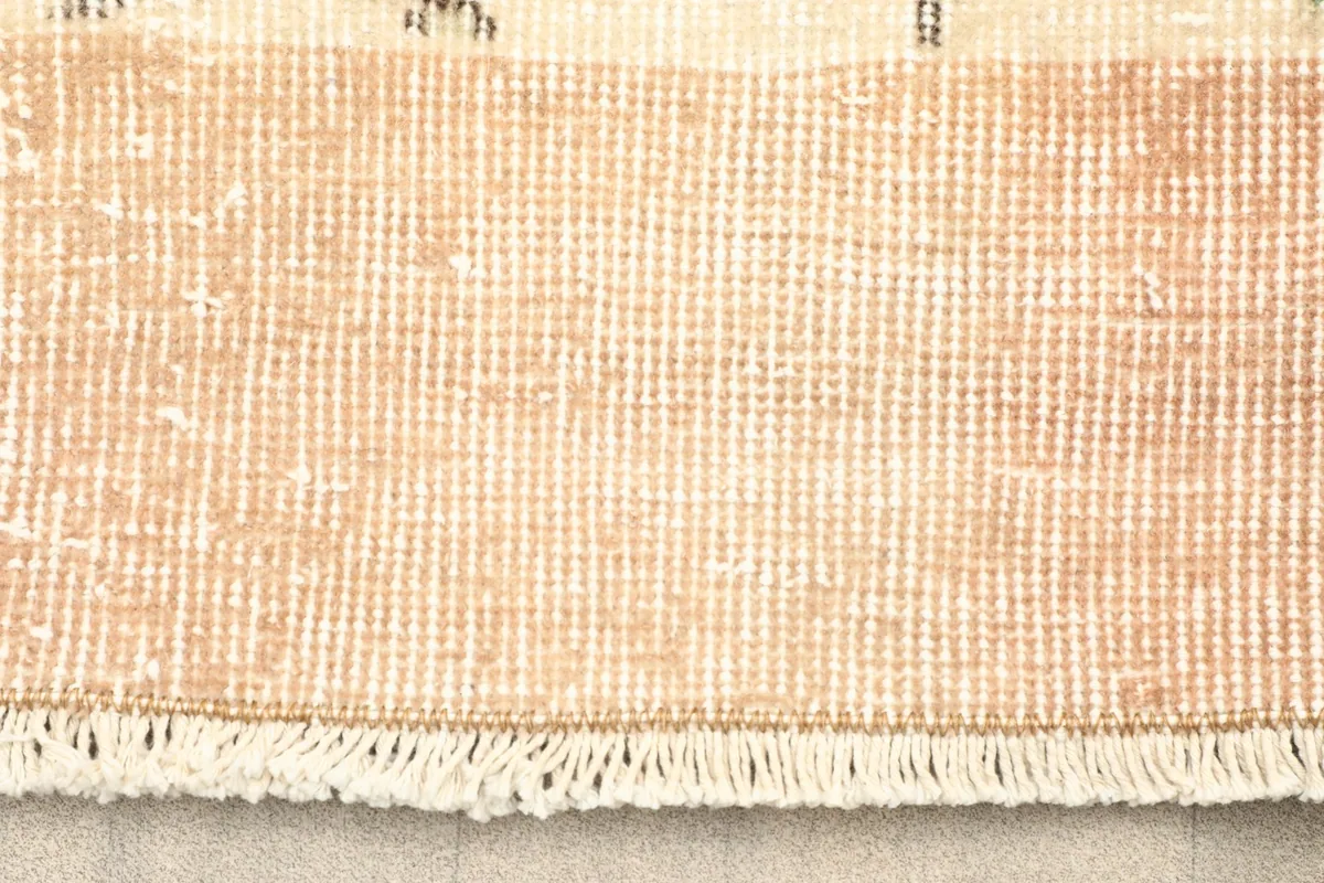 Close-up view of the back of the hand-knotted wool rug, showing the cotton foundation