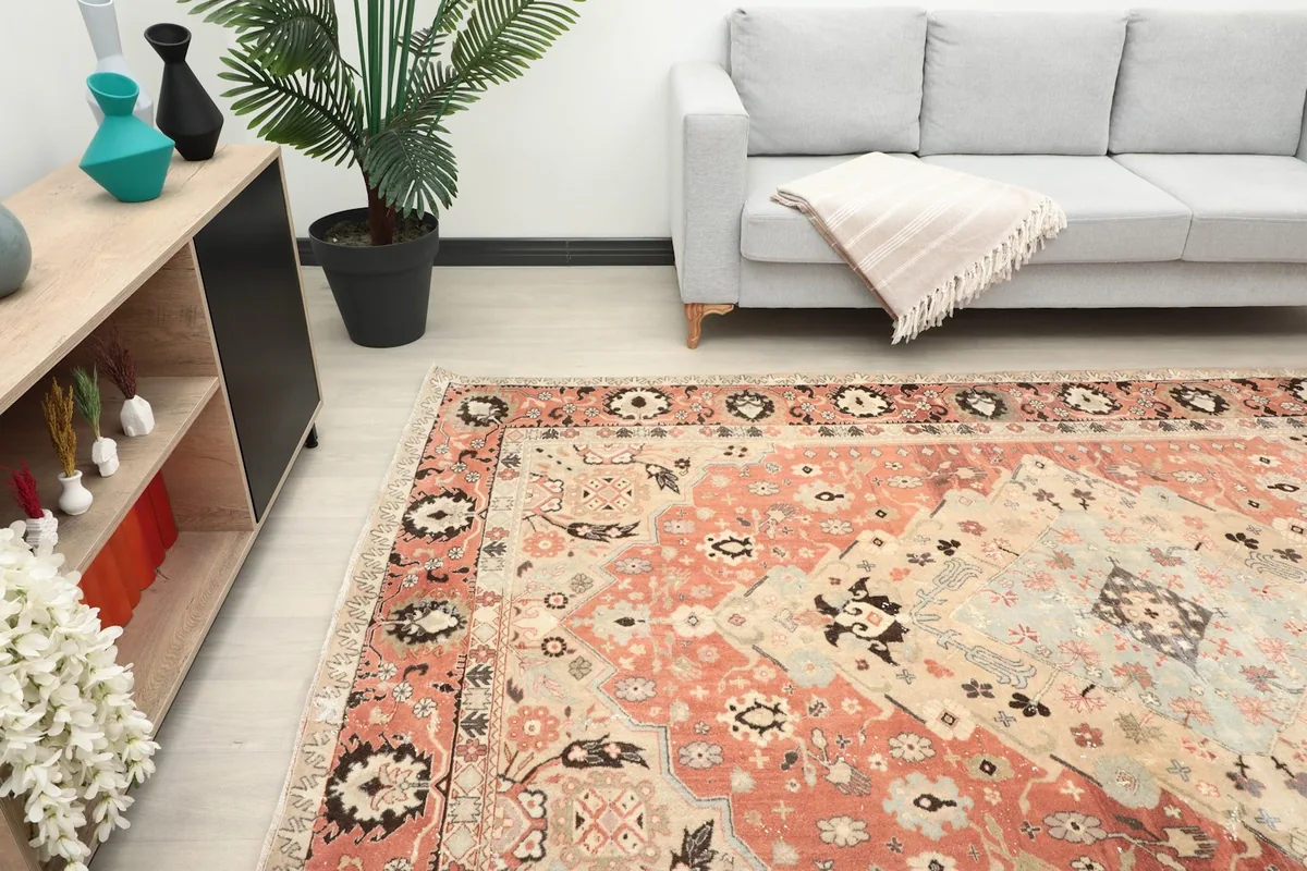 Side view of the rose area rug in a room setting, showing its scale next to furniture