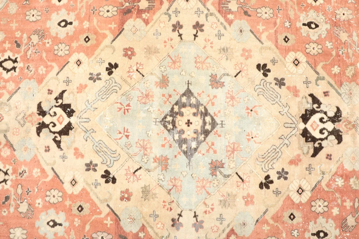 Detailed view of the central ivory and light blue medallion motif on the rug