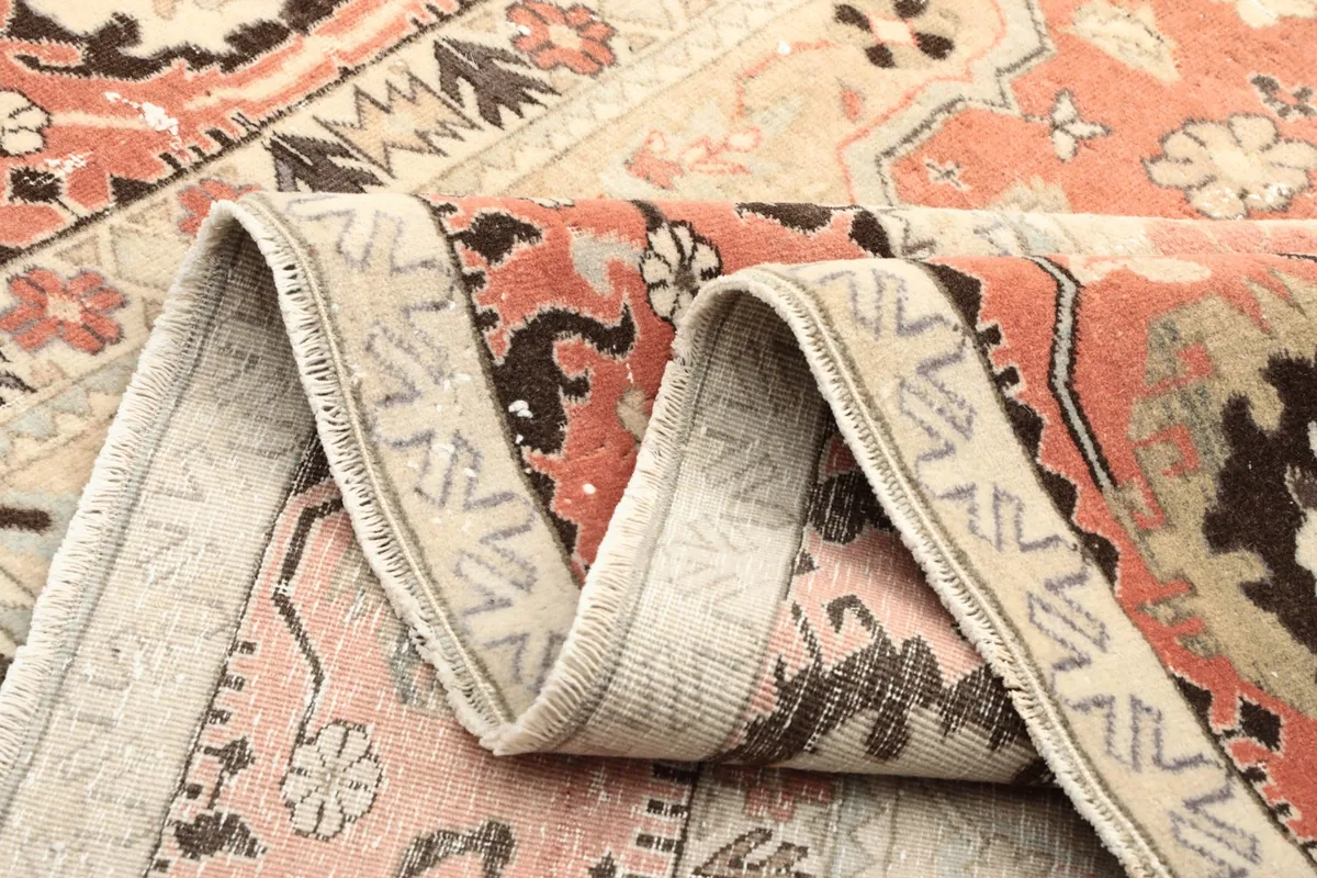 Rolled edge of the vintage wool rug, highlighting the low pile and hand-knotted texture