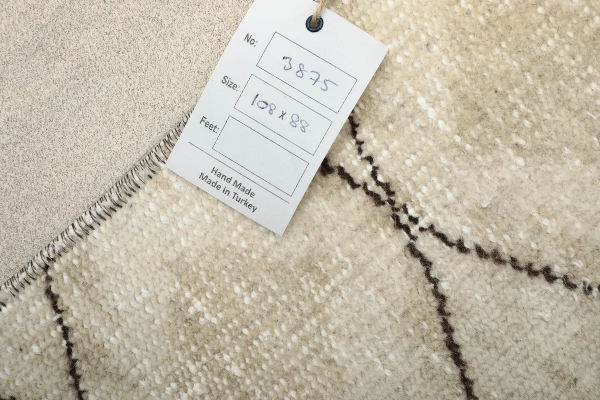 Back of the rug with a size tag, showing the tightly woven cotton foundation