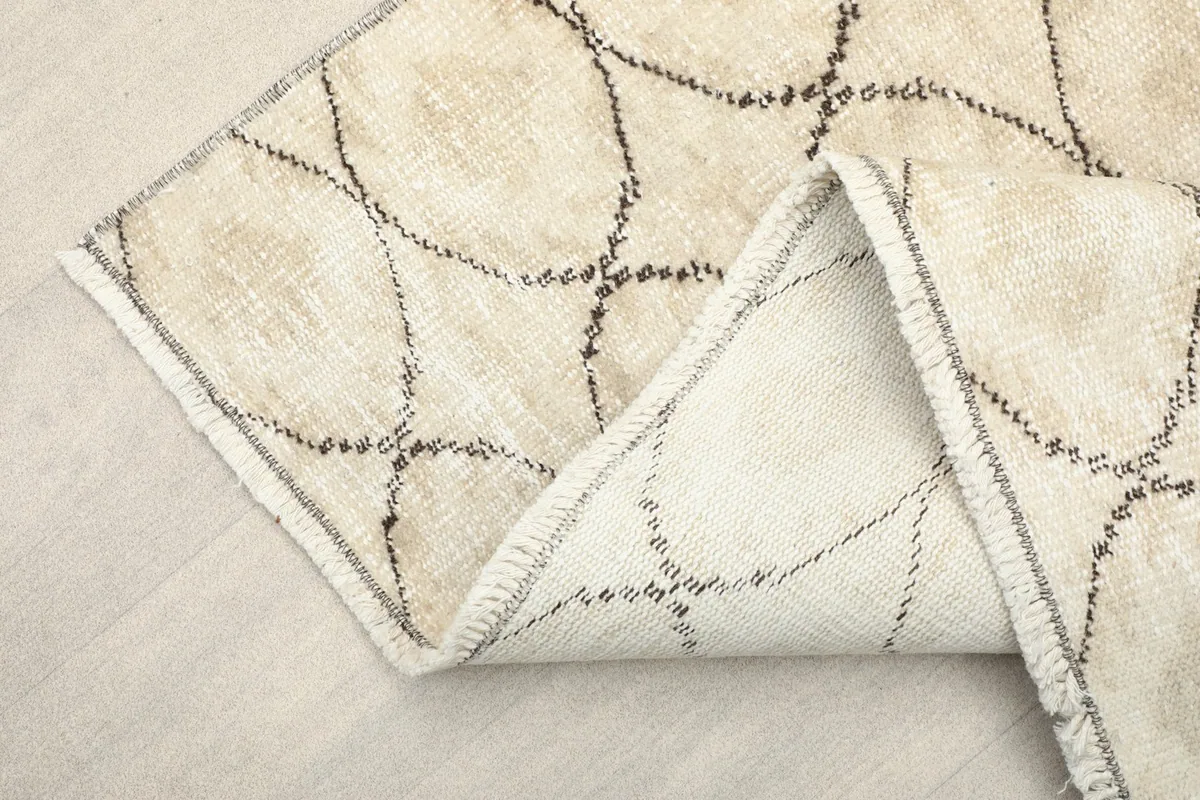 Corner of the rug folded to show the wool pile and cotton foundation