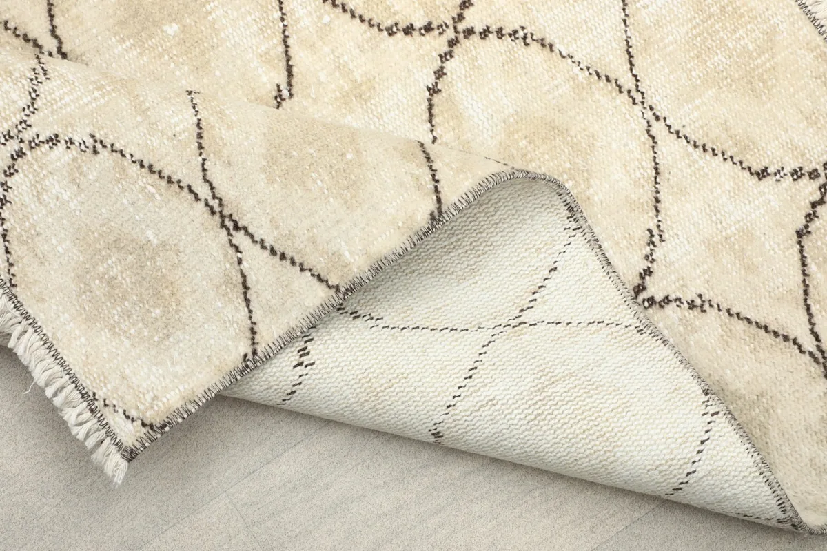 Close-up of the rug's edge and reverse, showing the cotton foundation