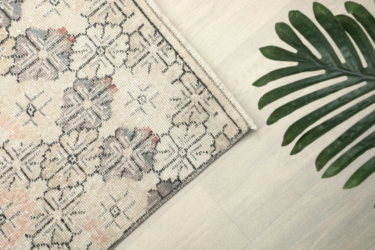 Angled view of the rug's surface next to a plant, emphasizing texture and pattern