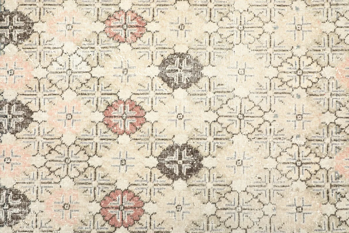 Close-up of the geometric floral motifs in rose, gray, and beige colors