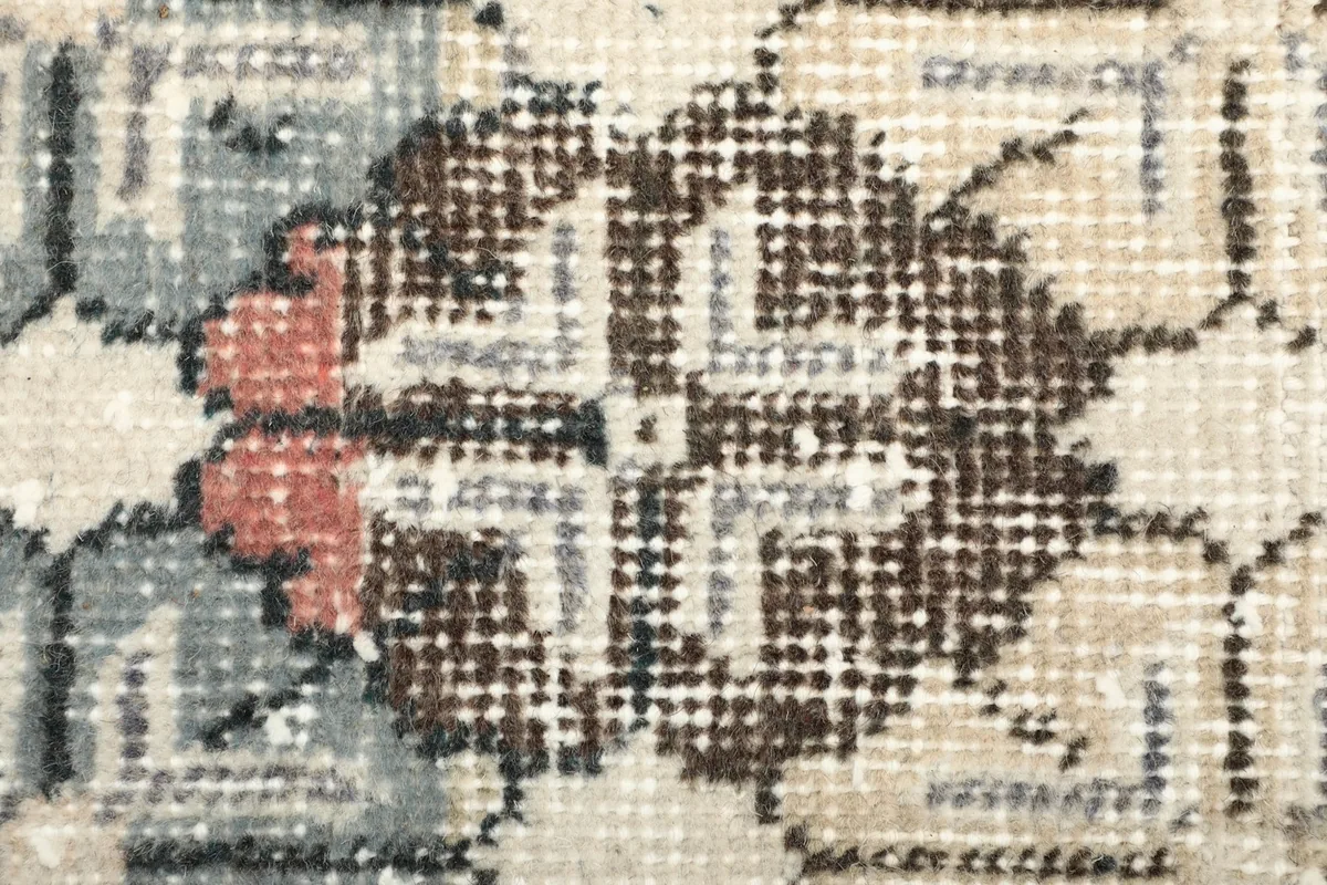 Detailed shot of a single floral motif, showing the intricate knotting and color variation