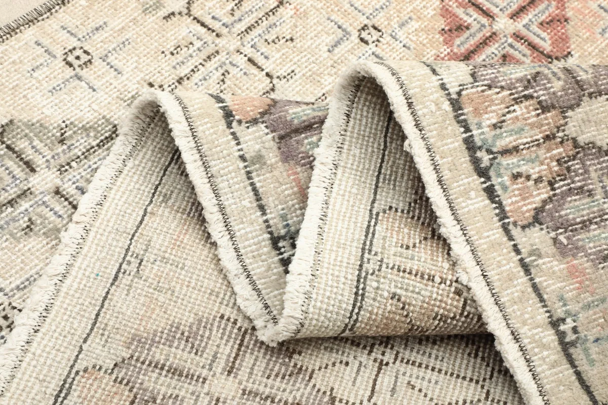 View of the rug's underside and folded edge, showing the construction