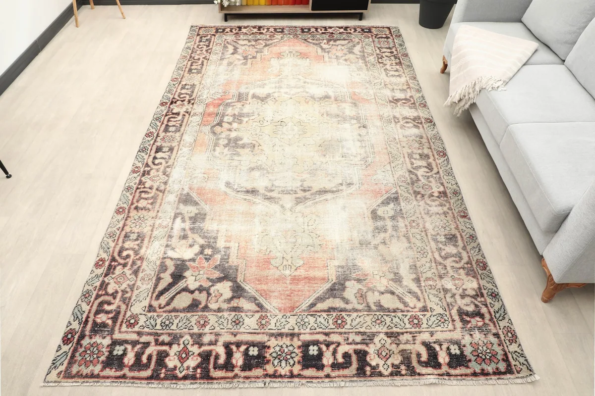 Vintage Anatolian rug displayed in a living room setting with a gray sofa