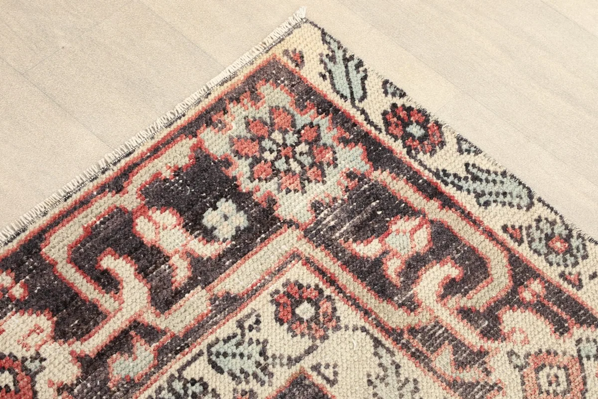 Corner detail showing the intricate rose, black, and beige border design