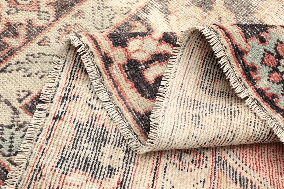 View of the rug's back, showing the hand-knotted wool pile on a cotton foundation