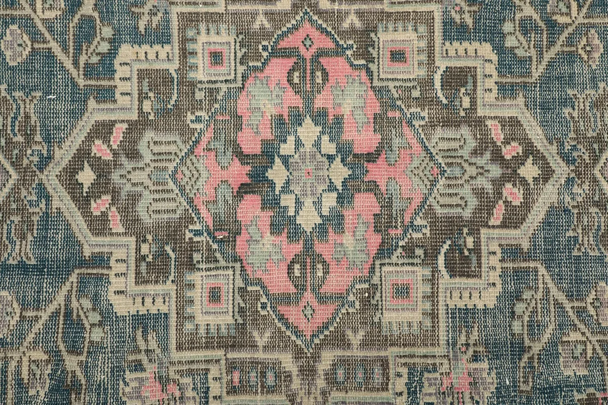 Detailed close-up of the central medallion design in rose, beige, and blue tones.