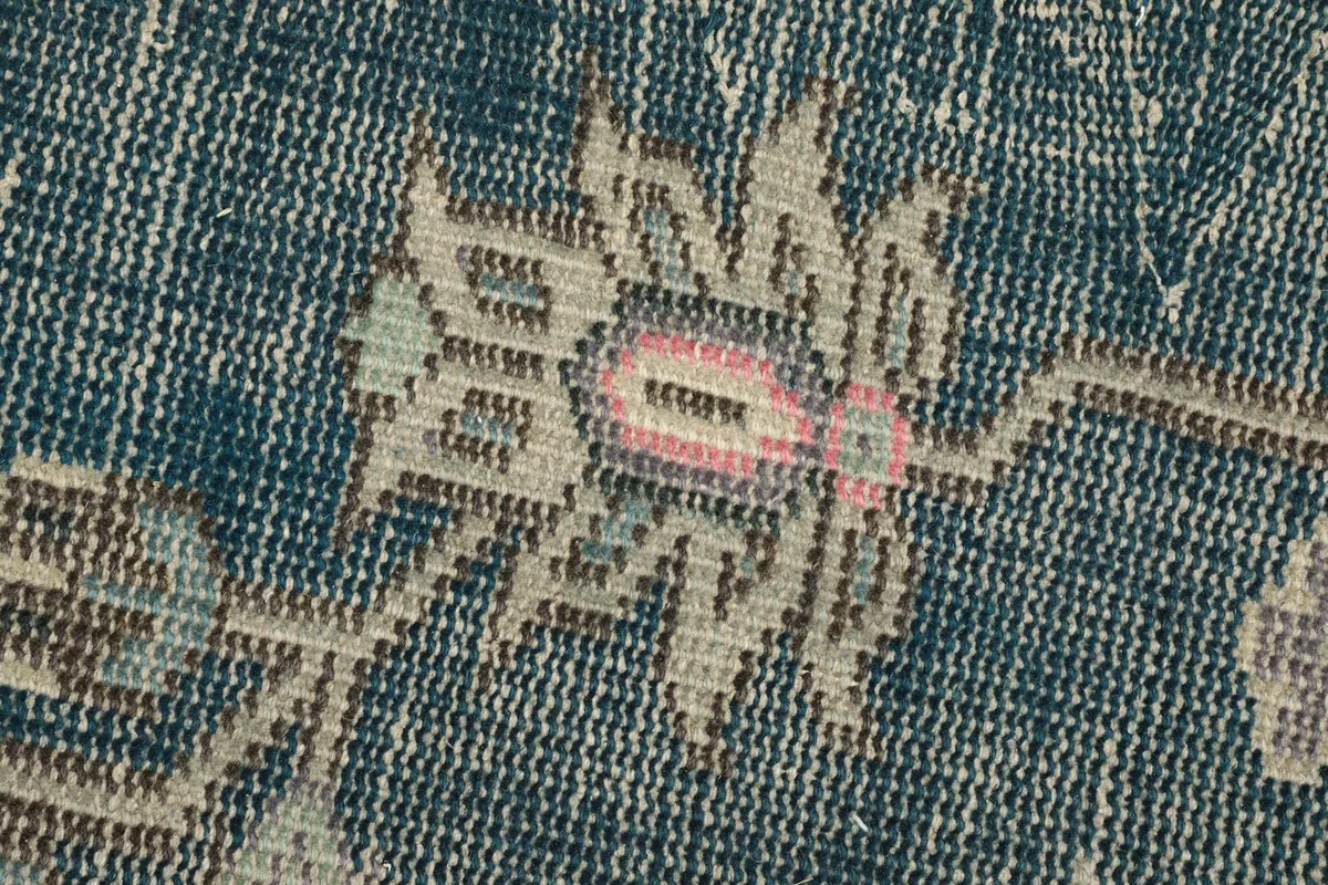 Close-up showing the low pile and texture of the hand-knotted wool on the blue field.