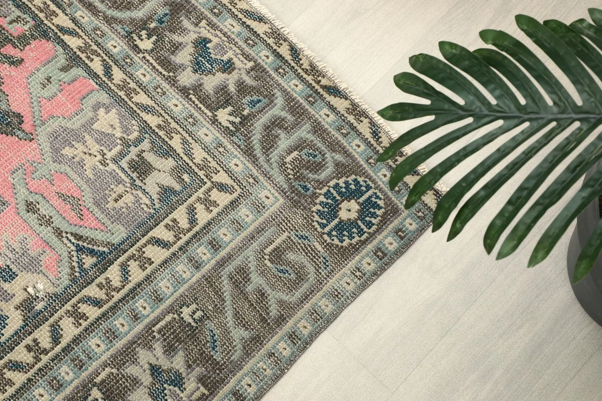 Close-up of the intricate border pattern with blue, beige, and gray motifs.