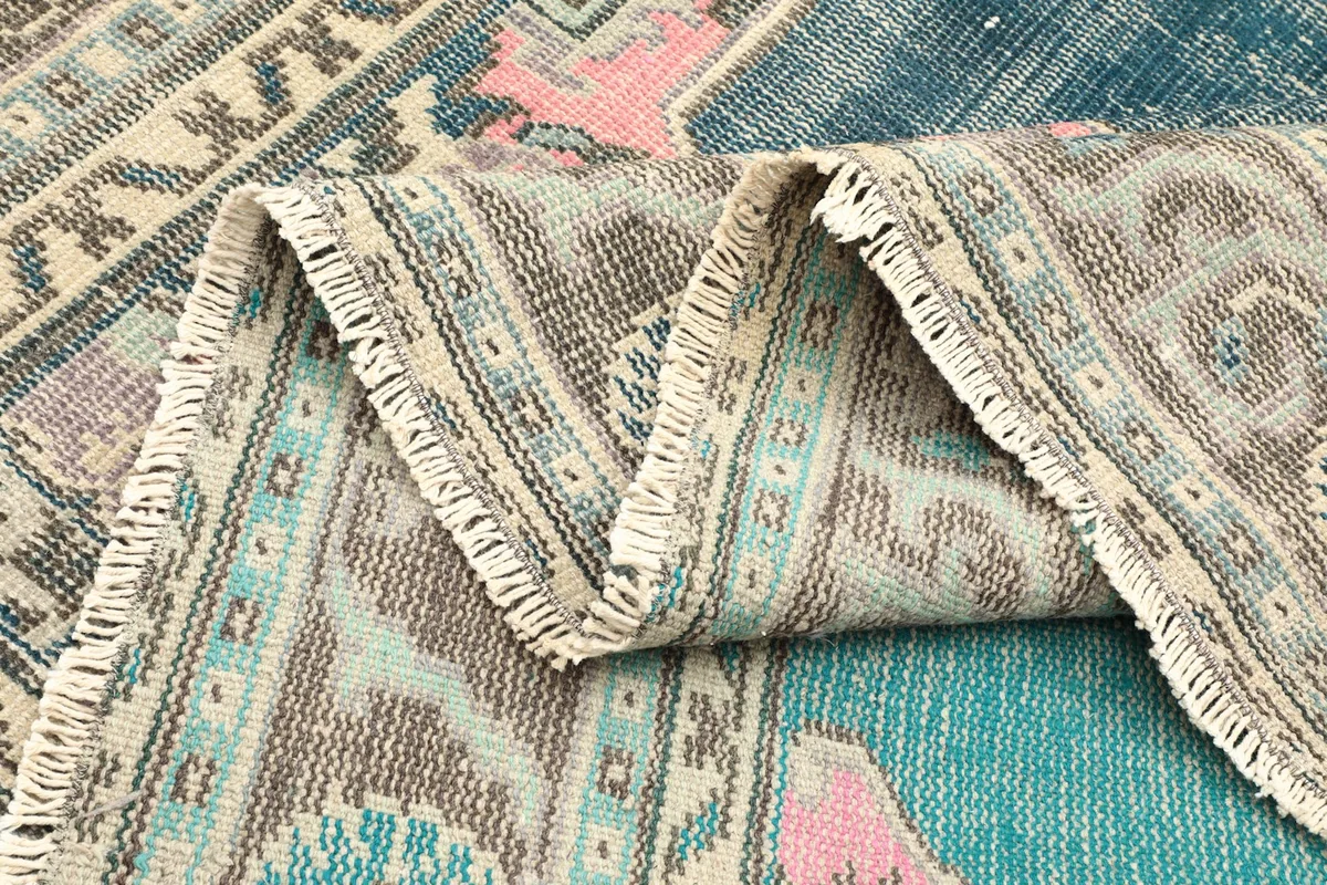 Side view of the rug folded, showing the thickness and the consistent knotting.