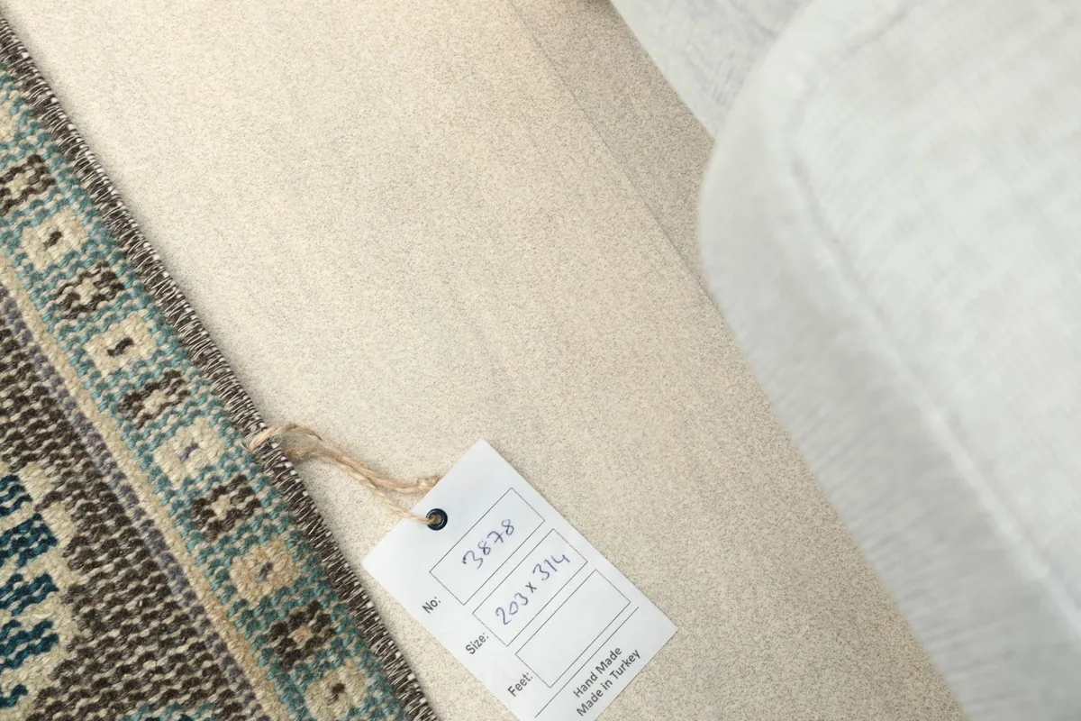 Close-up of the rug's label indicating size 203x314 cm and origin.