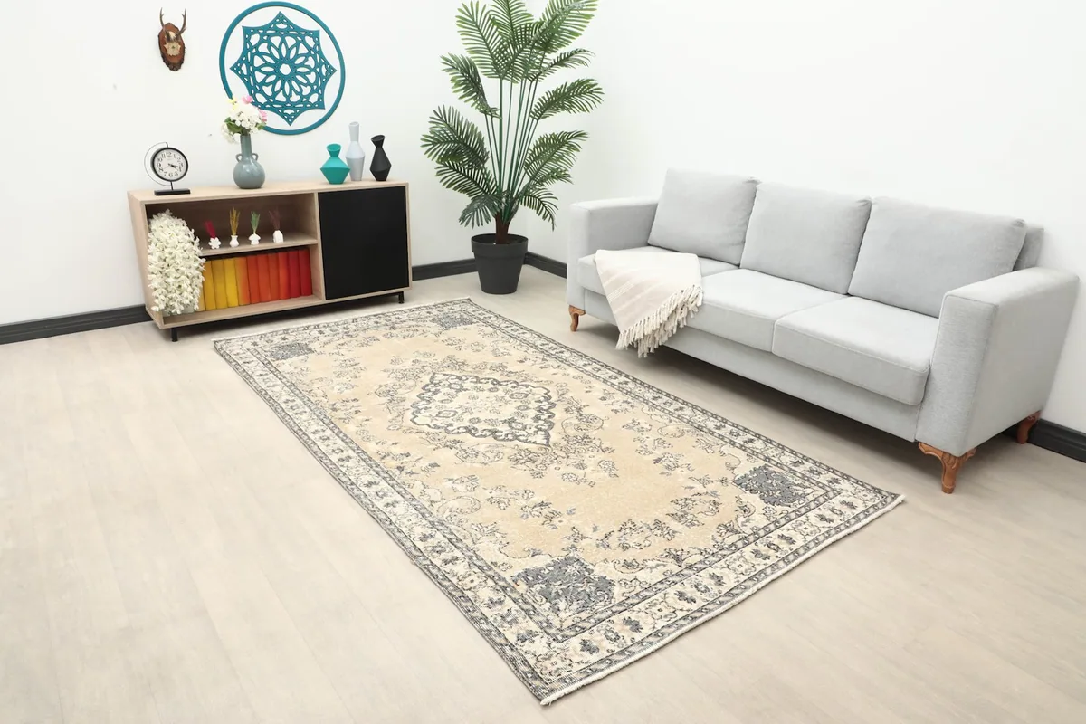 Wide view of the tan and charcoal rug in a room with a sofa and cabinet