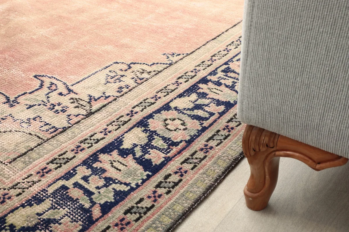 Detail of the rug's border next to a couch leg, showing how it complements home decor