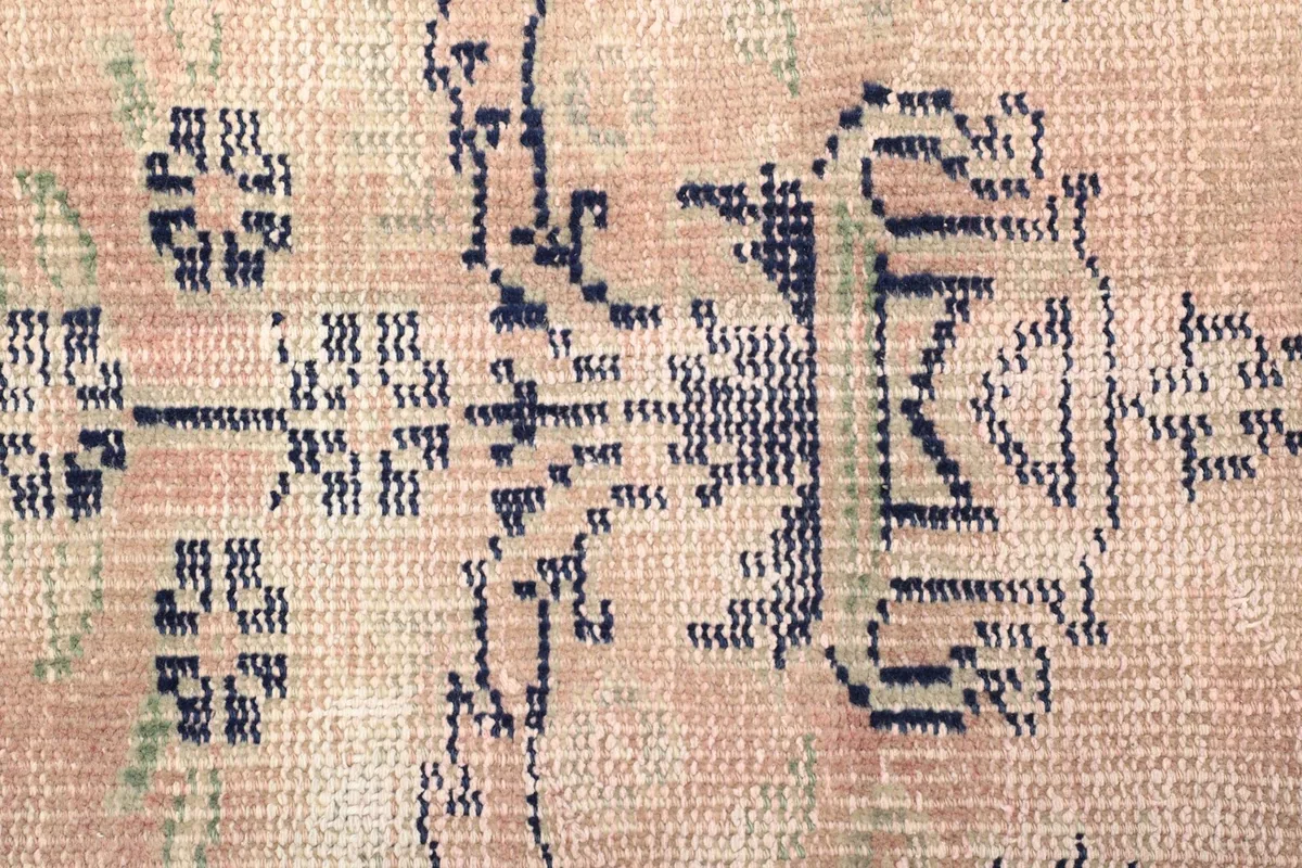 Macro detail of the hand-knotted wool pile, revealing the texture and subtle color variations