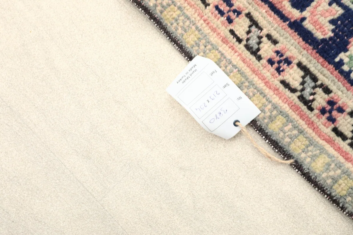 View of the rug's reverse side with a label, showing the tight hand-knotting and cotton foundation