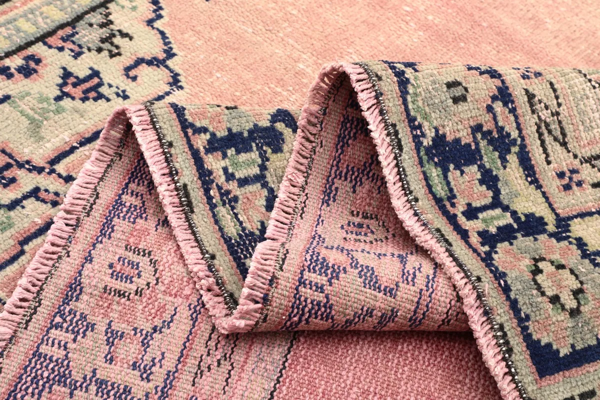 Rug folded to display the thickness of the wool pile and the texture of the weave