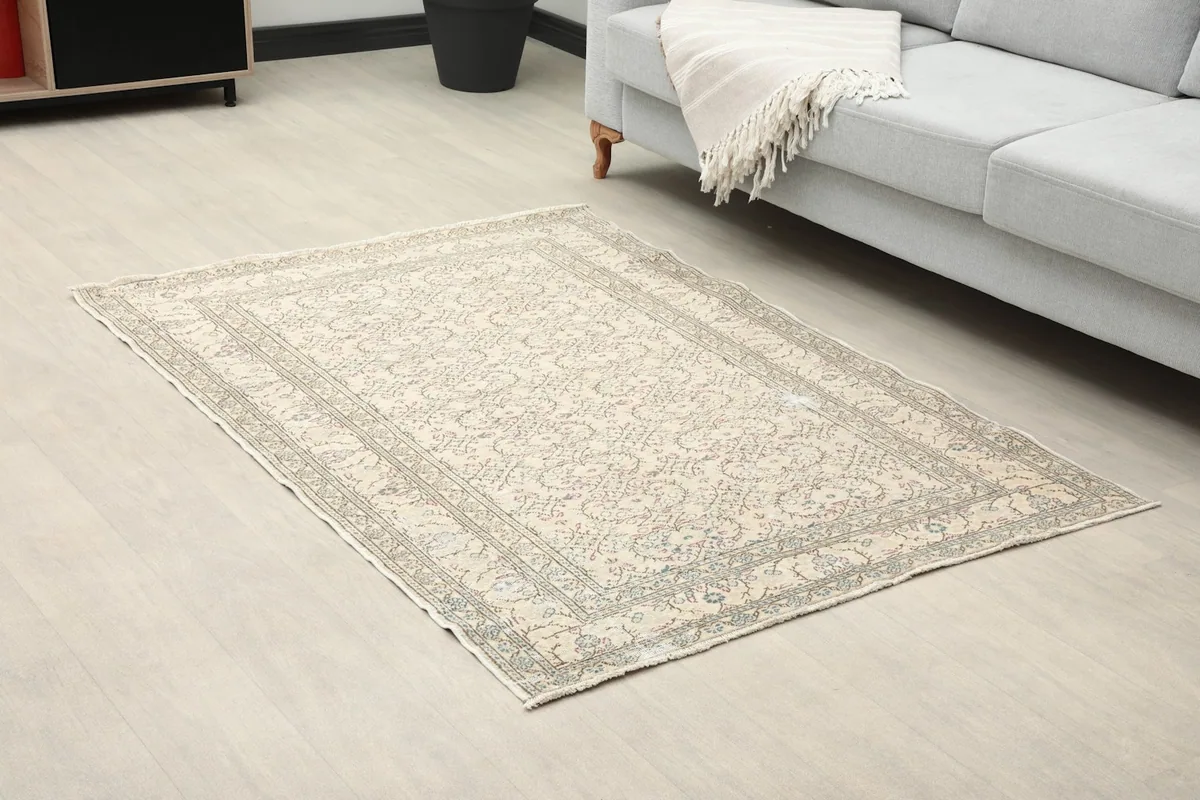 Angle view of the small ivory vintage rug complementing a modern living room setting