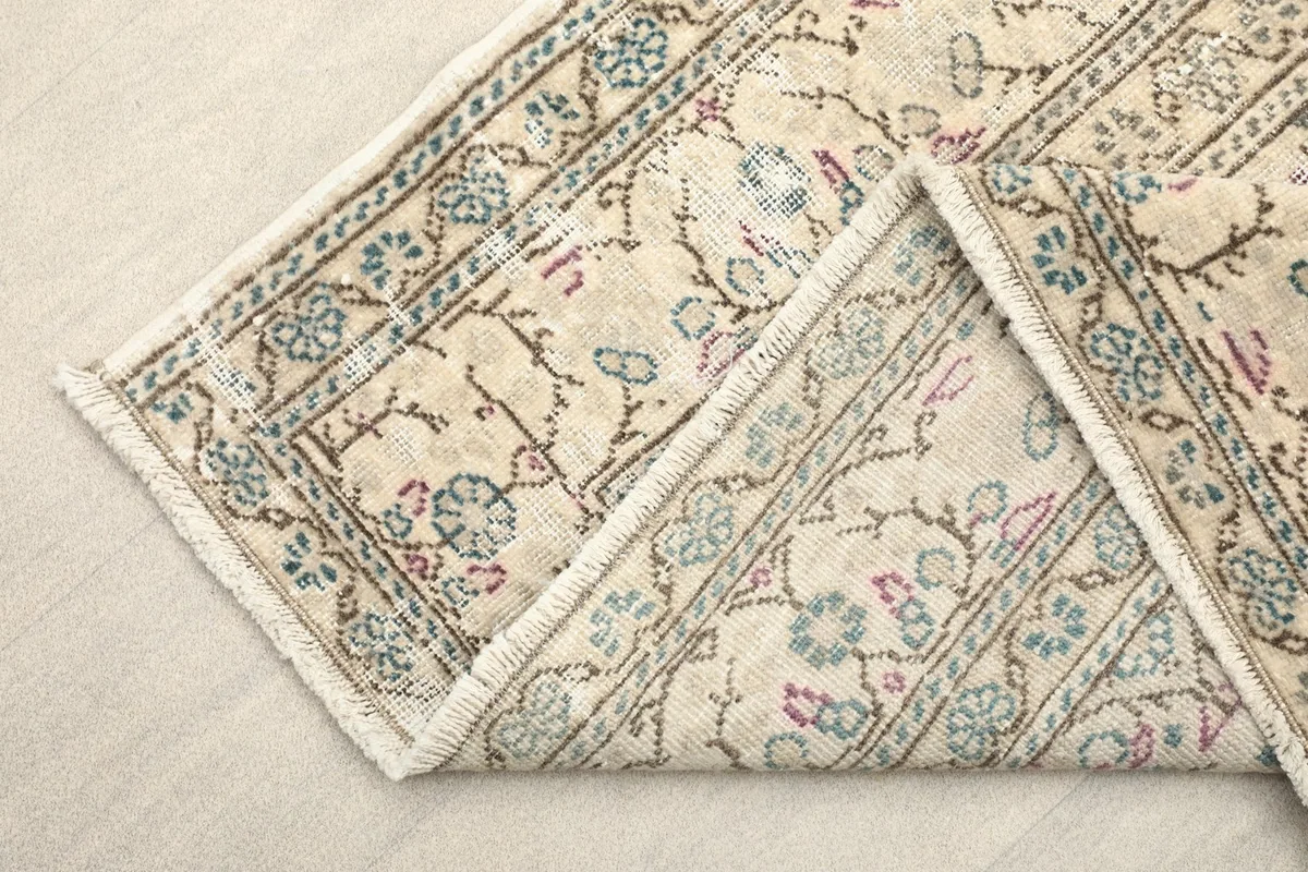Folded corner of the rug revealing the cotton foundation and fine knotting on the back