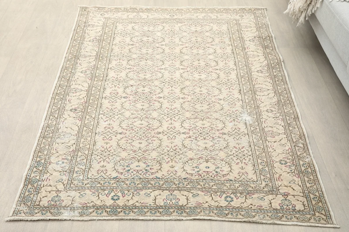 Overhead view of the ivory and gray vintage rug placed on a light wooden floor