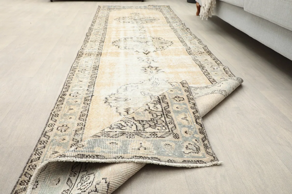 Angled view showing the rug partially rolled back, highlighting the reverse side.
