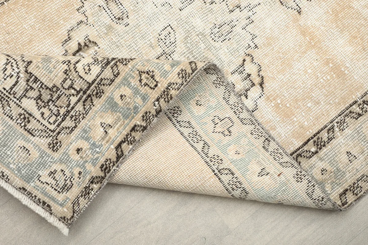 Close-up of the rug's reverse side, showing the hand-knotted construction and cotton foundation.