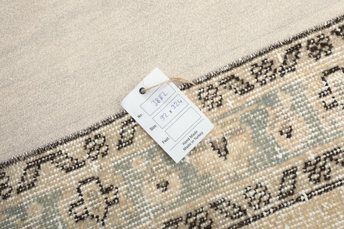 A tag displaying the rug's size (92 x 324 cm) and origin (Hand Made in Turkey) on the rug.