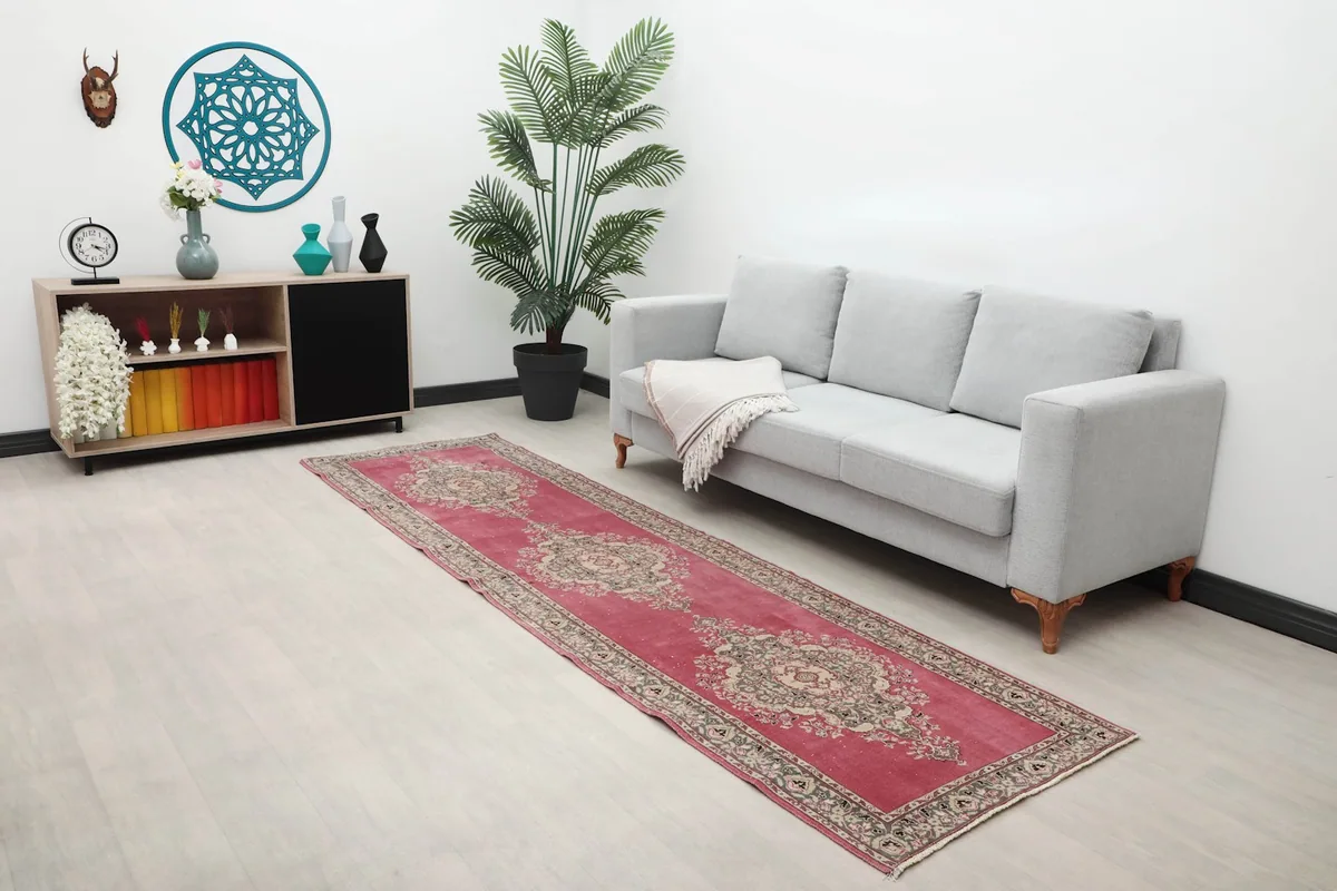 Rose runner rug displayed in a room setting next to a gray sofa and console table