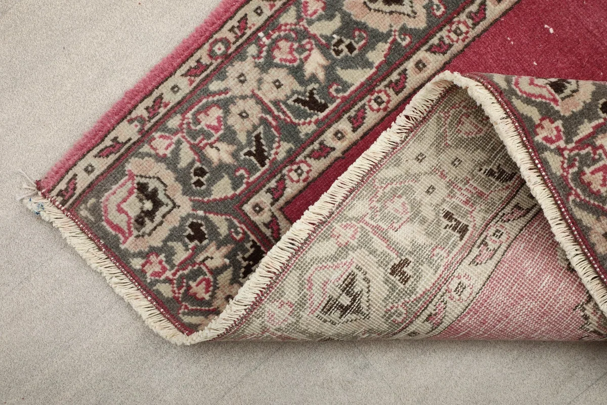 View of the runner rug folded to show the underside and the end fringe