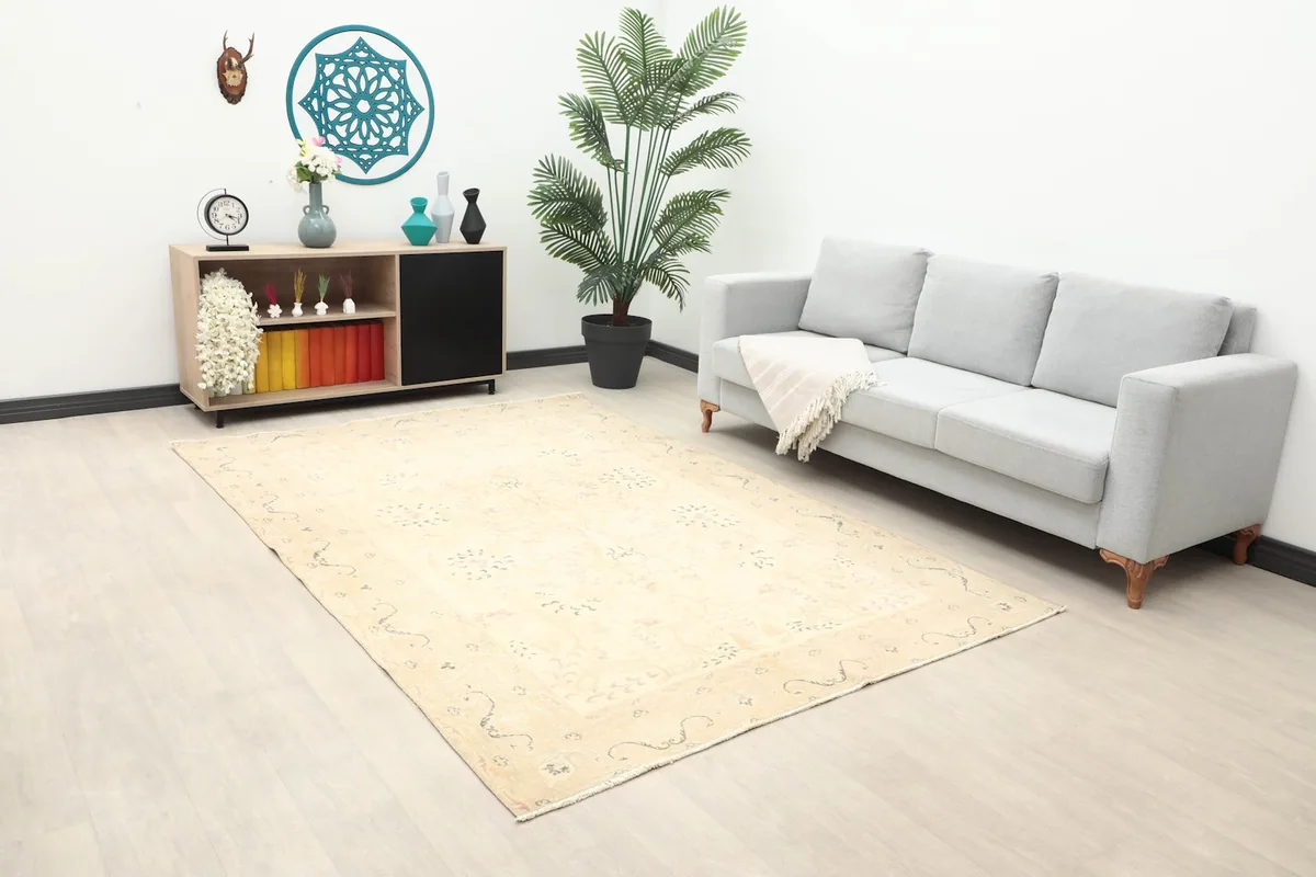 Ivory floral rug in a spacious room, showing its full size next to a sofa and cabinet.