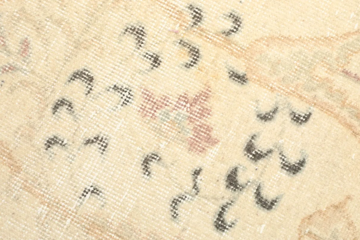 Close-up of the low wool pile, revealing the texture and subtle color variations of the vintage rug.