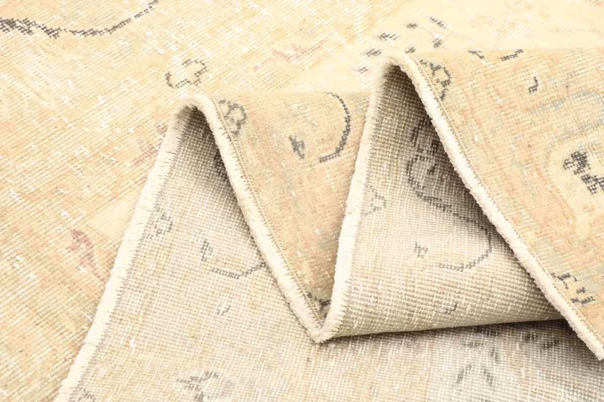 Rug folded to display its thickness and the reverse side, confirming its hand-knotted construction.