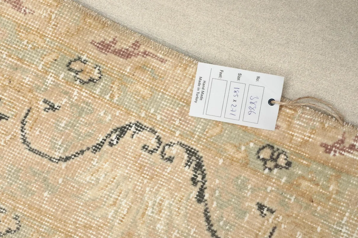 Close-up of a rug tag showing size and origin details, resting on the rug's patterned surface.