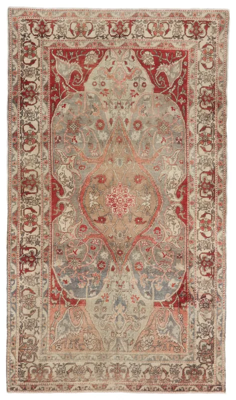 Full overhead view of the vintage gray and red Anatolian rug with a central medallion on a white background