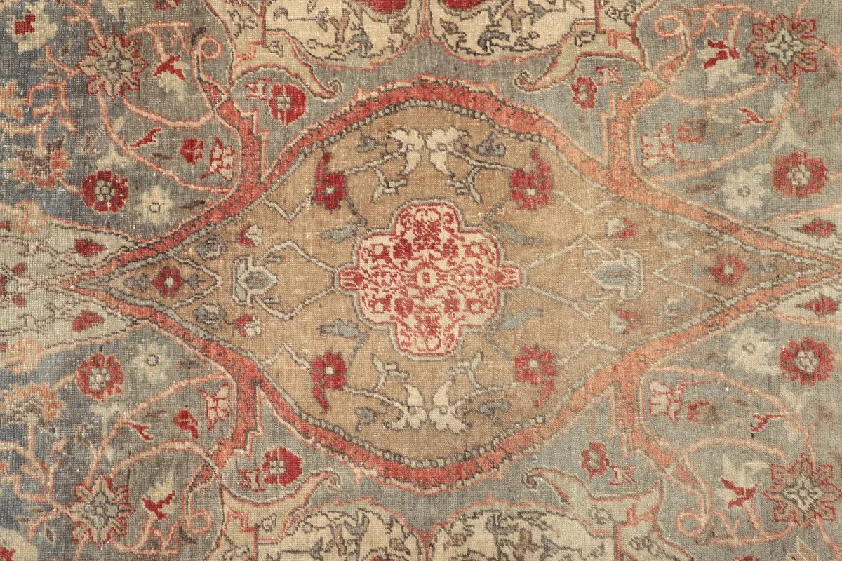 Close-up of the central medallion with red and gray floral patterns