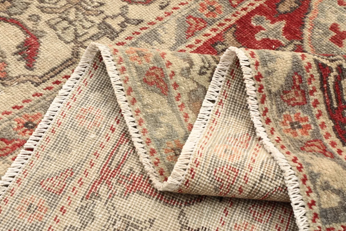 Side view of the rug folded, showing the thickness and construction of the hand-knotted wool pile