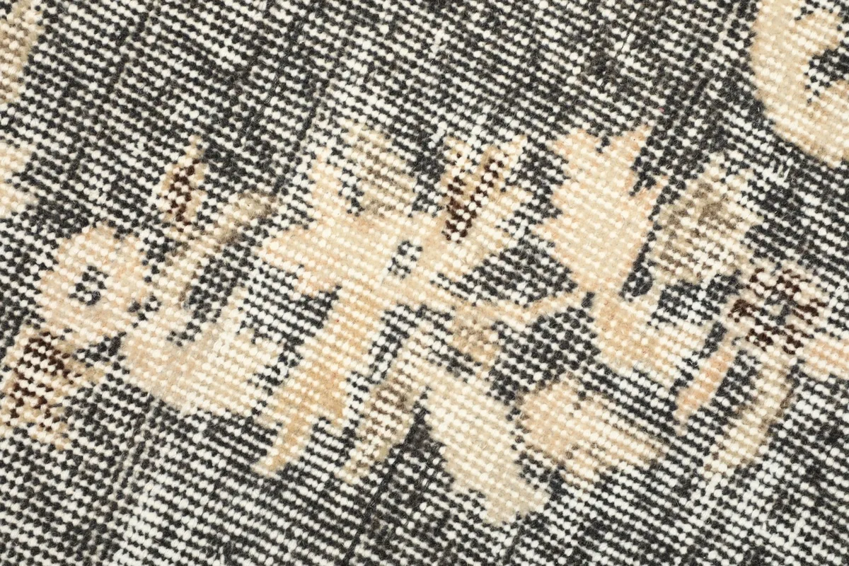 Detailed view of the low wool pile and hand-knotted texture of the vintage rug